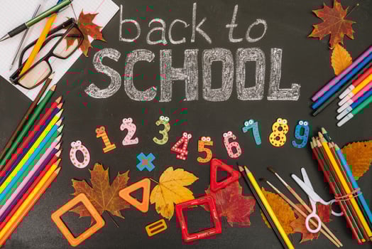Back to school concept. School and office supplies on blackboard background photo