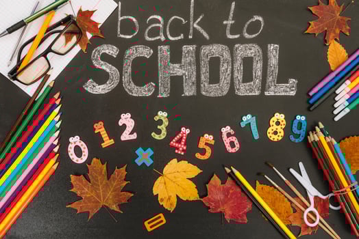 Back to school concept. School and office supplies on blackboard background photo