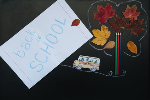 Back to school concept. School and office supplies on blackboard background photo