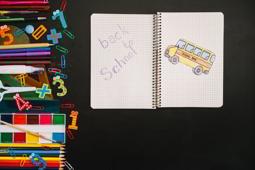 Back to school concept. School and office supplies on blackboard background photo