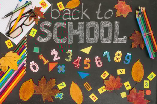 Back to school concept. School and office supplies on blackboard background photo