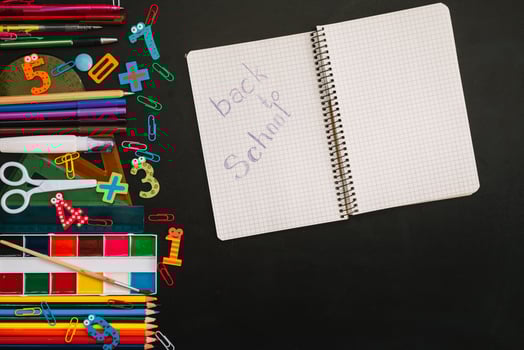 Back to school concept. School and office supplies on blackboard background photo