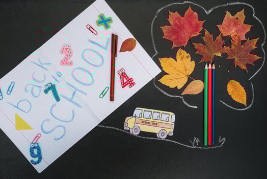 Back to school concept. School and office supplies on blackboard background photo