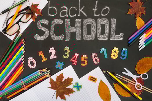 Back to school concept. School and office supplies on blackboard background photo
