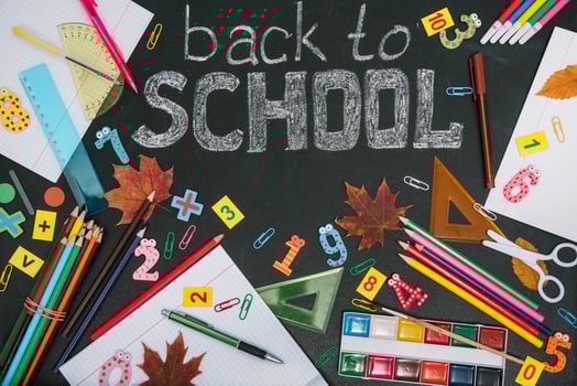 Back to school concept. School and office supplies on blackboard background photo