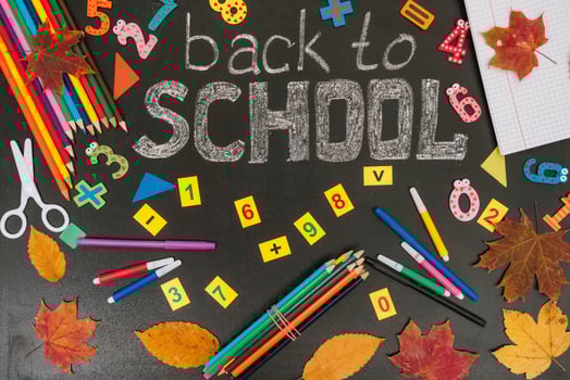 Back to school concept. School and office supplies on blackboard background photo