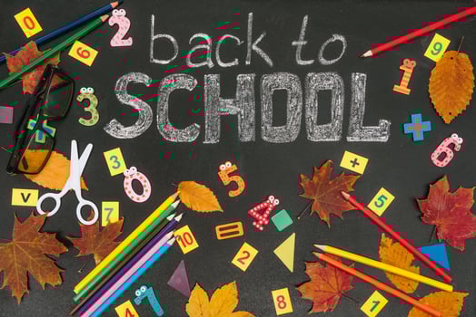 Back to school concept. School and office supplies on blackboard background photo