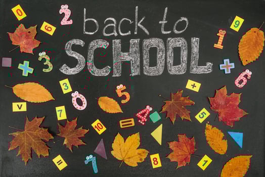 Back to school concept. School and office supplies on blackboard background photo