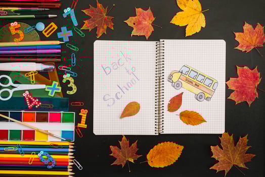 Back to school concept. School and office supplies on blackboard background photo