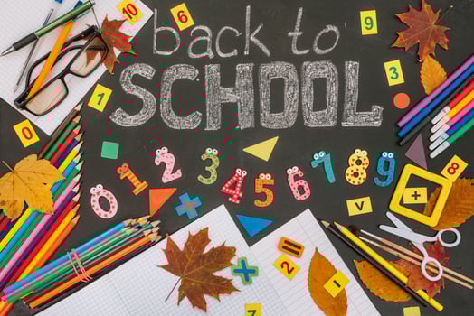 Back to school concept. School and office supplies on blackboard background photo