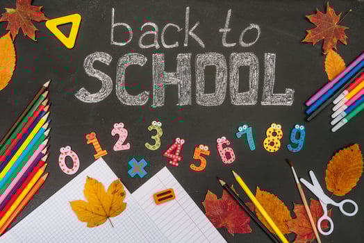 Back to school concept. School and office supplies on blackboard background photo