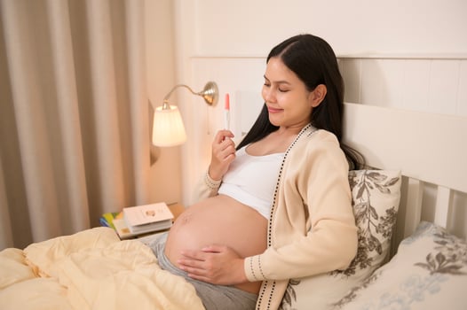 Beautiful pregnant woman holding positive pregnancy test, fertility infertility treatment, IVF, future maternity concept photo