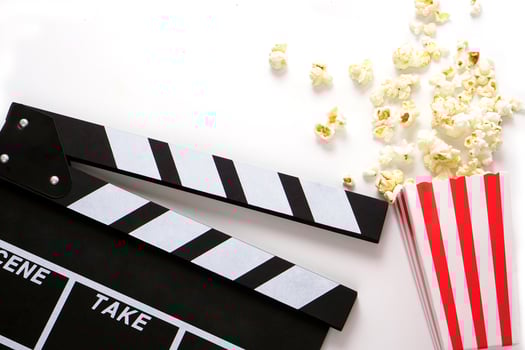 Clapperboard or movie slate black color with popcorn on white background. Cinema industry, production and film concept. photo