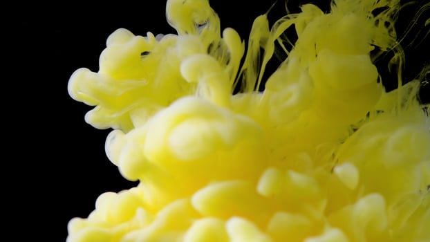 Ink in water. yellow ink drops in water and mixes, swirling softly underwater on black background. acrylic cloud paint in aquarium. Abstract smoke explosion animation photo
