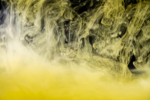 clouds of yellow smoke on a black background, clouds of paint in water, aquarium, abstract background, texture photo