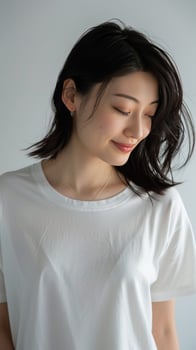 A photo of a young woman with short black hair and a white shirt