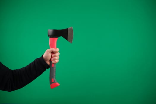 Male hand holding an axe with wooden handle advertising Green background chromakey copy space photo