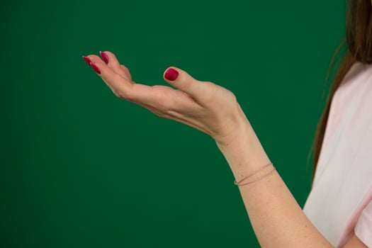 beautiful woman hand holding something and pointing with finger in position body parts of a young woman on a green background chromakey photo