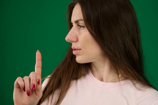 beautiful woman showing expressions. different emotions of a young girl on a green background chromakey beautiful facial features real people pink T-shirt white skinned. European photo