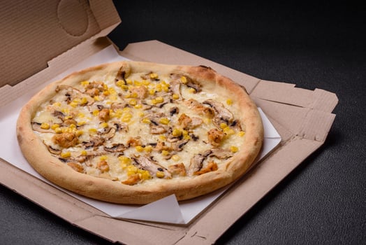 Delicious pizza with corn, cheese, tomatoes and mushrooms, salt, spices and herbs photo