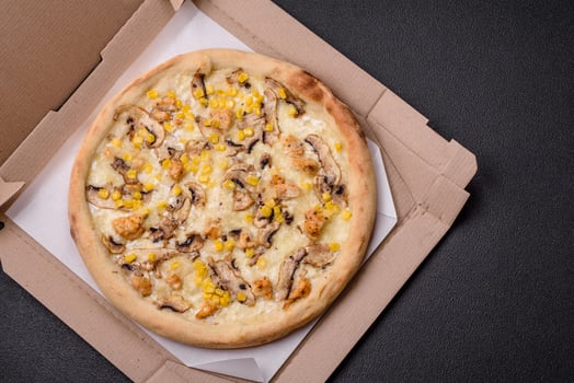Delicious pizza with corn, cheese, tomatoes and mushrooms, salt, spices and herbs photo