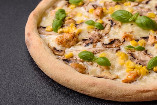 Delicious pizza with corn, cheese, tomatoes and mushrooms, salt, spices and herbs photo