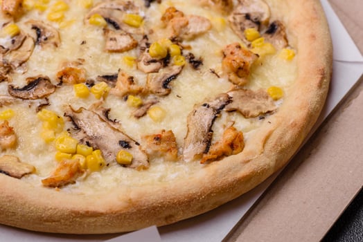 Delicious pizza with corn, cheese, tomatoes and mushrooms, salt, spices and herbs photo