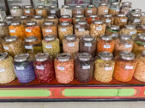 various types of snacks such as pickled fruit and nuts in glass jars photo