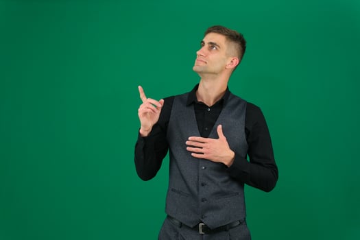 young man doing a winner gesture emotions of a handsome man guy on a green background chromakey close-up dark hair young man photo