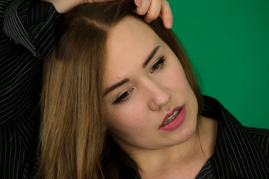 Portrait of the young girl with horns woman on a green background chromakey in a black striped mens shirt different emotions facial expression close-up advertising space for text clean. kind eyes photo