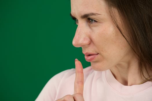 Young girl making silence gesture on green background different emotions of a young girl on a green background chromakey beautiful facial features real people pink T-shirt white skinned. European photo