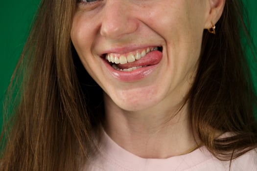 silly woman sticking out her tougne body parts of a young woman on a green background chromakey photo