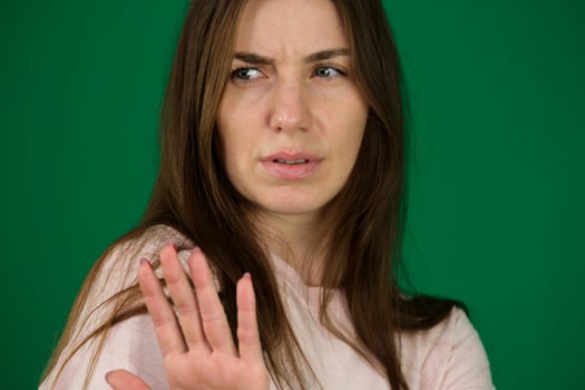 Abuse, adult, afraid. different emotions of a young girl on a green background chromakey beautiful facial features real people pink T-shirt white skinned. European photo