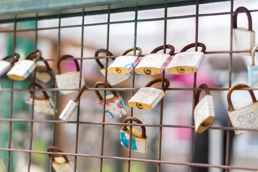A close up of love padlocks attached to a railing photo