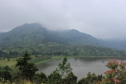 beautiful lake in the highland. View of the lake between the hill. The lake is surrounded by grasslands and shrouded in mist photo