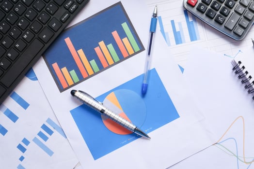 top view of financial charts and office stationary on table photo