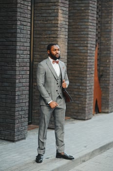 Fashion portrait of a handsome young African American business man walking outdoors in a casual pose. photo
