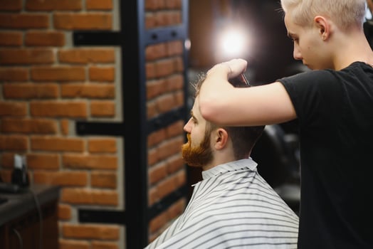 Close-up, master hairdresser does hairstyle and style with scissors and comb. Concept Barbershop photo