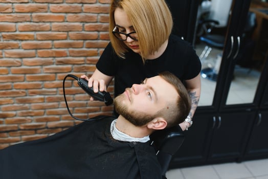 Client during beard shaving in barber shop photo