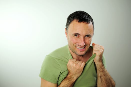 sly funny look adult unshaven man tears Green khaki T-shirt and bites his fingers 40-49 years Black hair at the temples gray Experience stress upset neurosis Studio white background photo