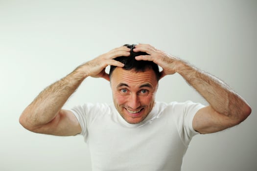 Win fun vacation travelDifferent cheerful positive emotions of an adult man with gray black hair Open funny cheerful blue eyes White t-shirt gray background wrinkle forehead stick out tongue photo