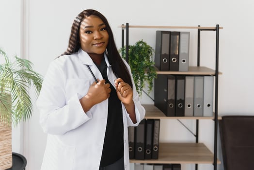 Portrait of beautiful smiling female african american doctor standing in medical office. Health care concept, medical insurance, copy space photo