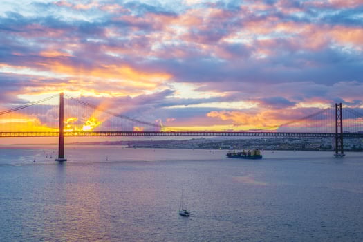 View of 25 de Abril Bridge over Tagus river on sunset. Lisbon, Portugal photo