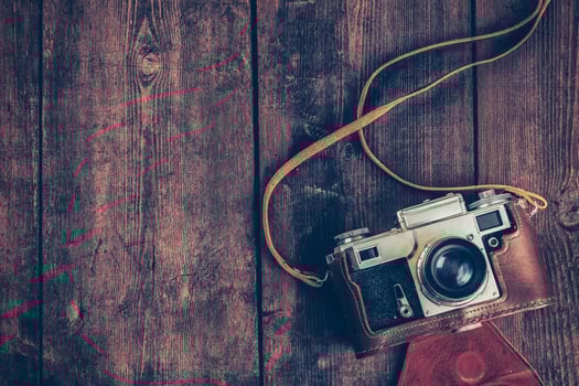 Old retro vintage camera on grunge wooden background photo