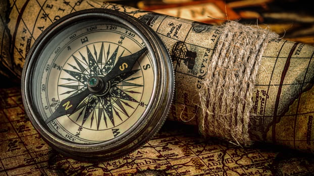 Old vintage compass on ancient map photo