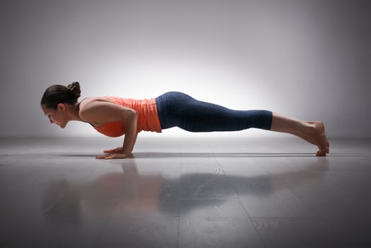 Woman practices yoga asana Chaturanga Dandasana photo