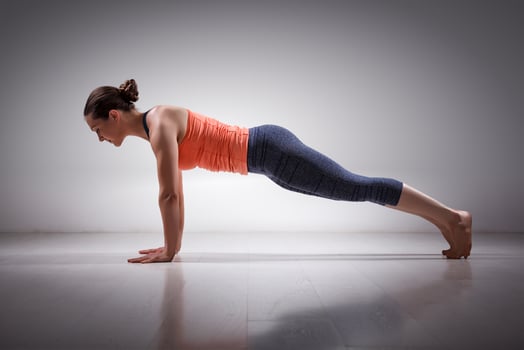 Woman does yoga asana Utthita Chaturanga Dandasa photo