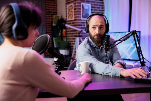 Show presenter interviewing designer during live stream, talking about fashion and style trends. Man having conversation with social media influencer, recording episode for podcast photo