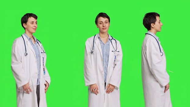 Portrait of physician wearing a white coat and a stethoscope for exams, standing against greenscreen backdrop. Doctor specialist working in healthcare industry, medical expertise. Camera B. photo