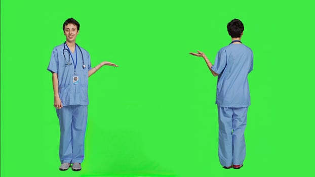 Medical assistant pointing at something aside and doing web commercial, creating advertisement against greenscreen backdrop. Young nurse with scrubs showing a thing to left or right sides. Camera A. photo